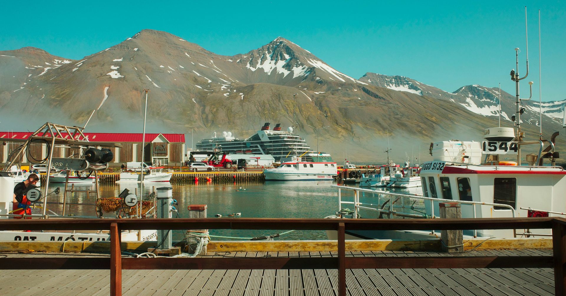 Boats docked in a harbor with mountains in background
